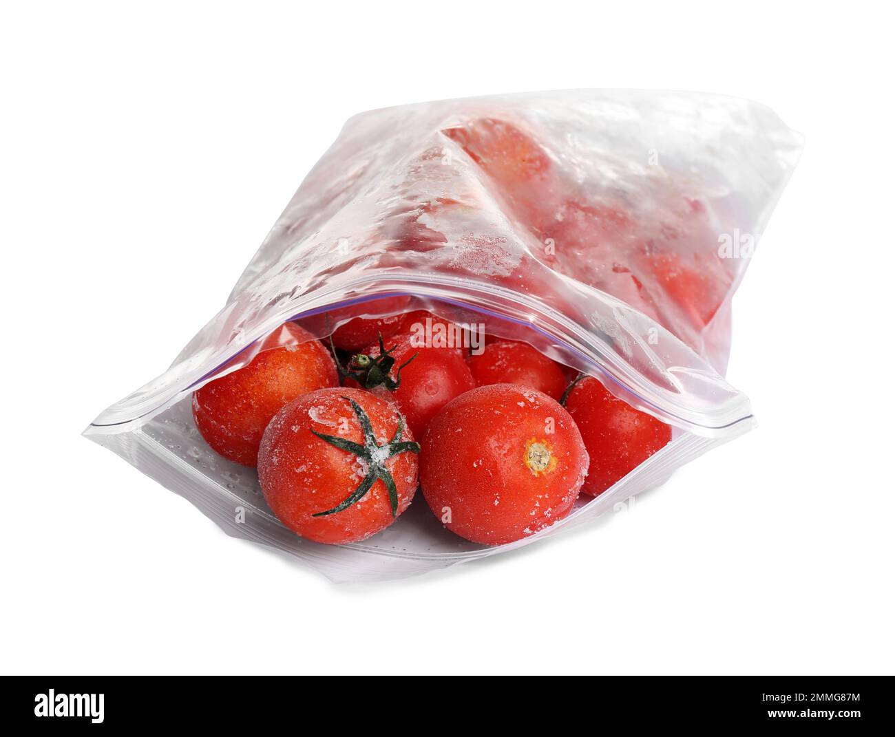 Frozen tomatoes in plastic bag isolated on white. Vegetable preservation Stock Photo