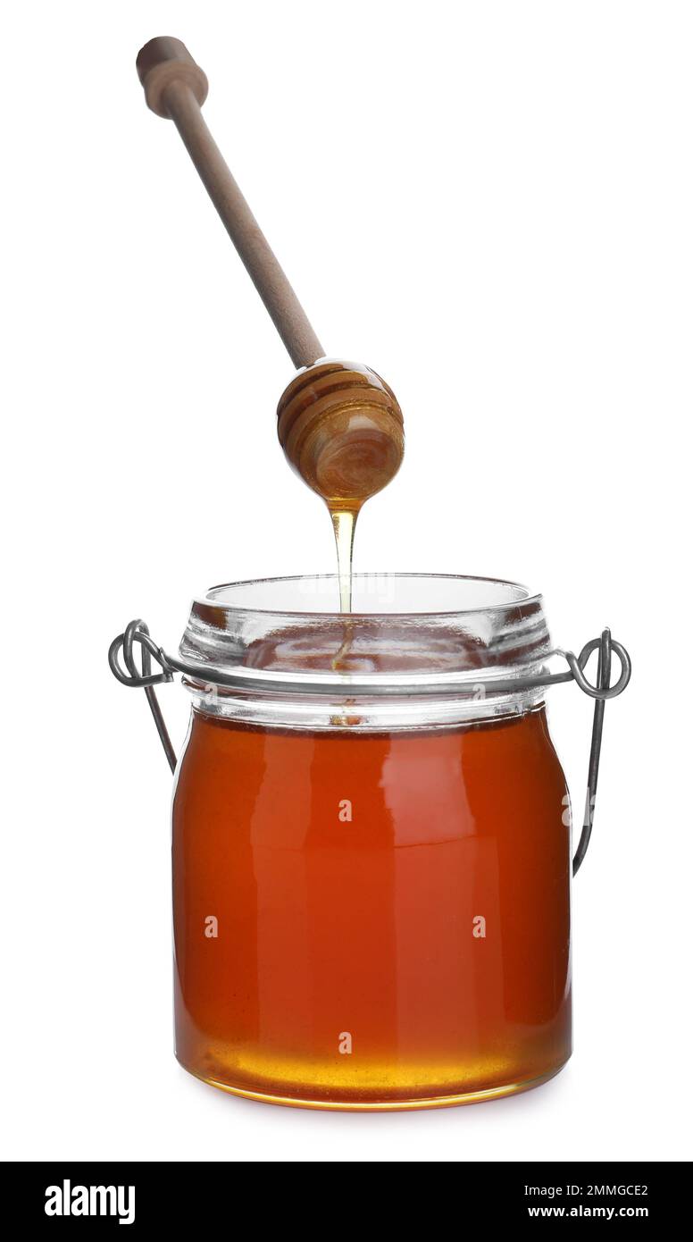Honey dripping from wooden dipper into jar isolated on white Stock ...