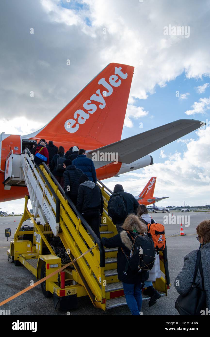 Easyjet passengers entering on Airbus airplane. Easyjet airplane tail. Easyjet airlines. Comercial Transport costs and fuel consumption. Comercial airlines. Stock Photo