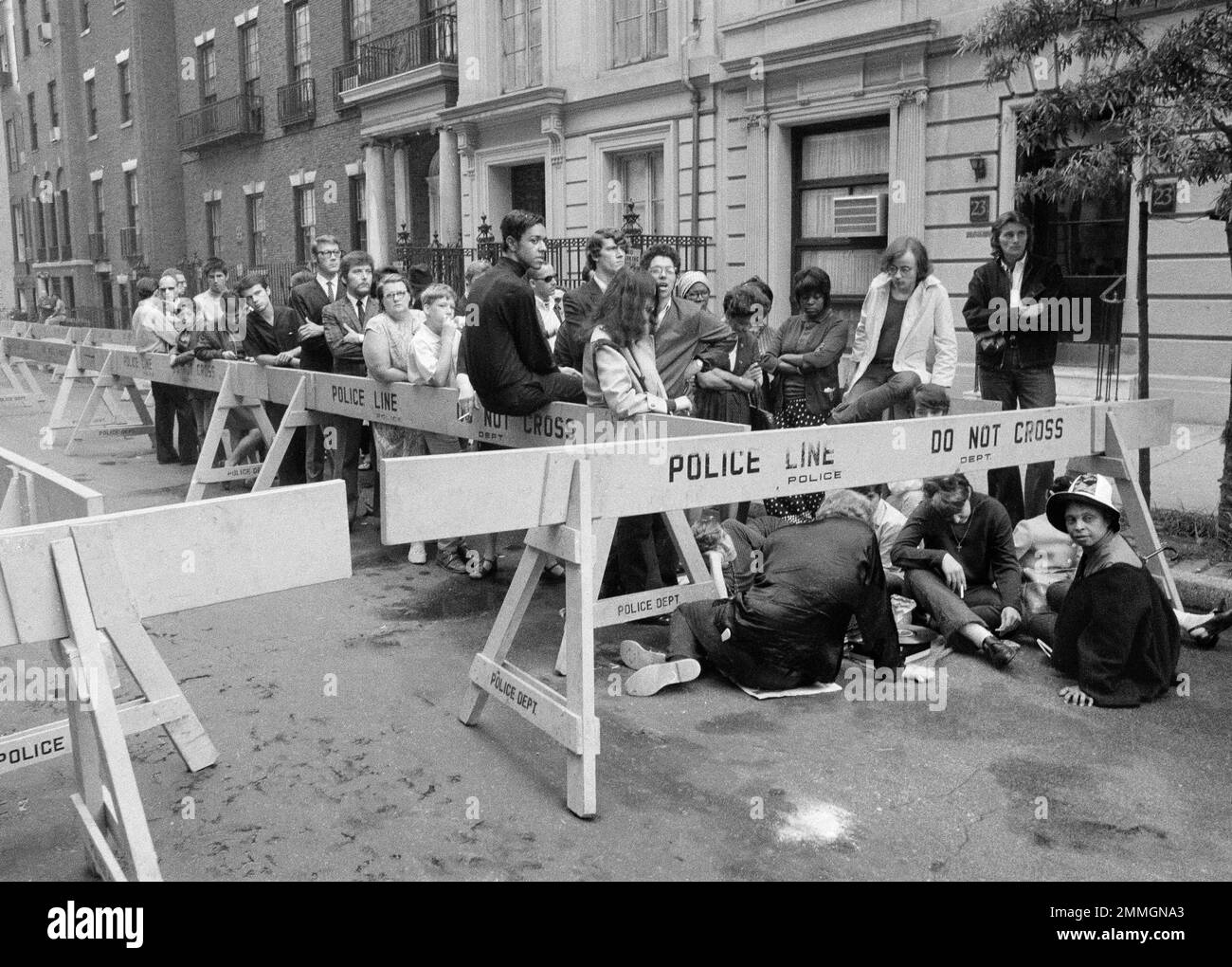Early arrivals wait behind police barricades outside the Frank E. Campbell funeral home on 81st