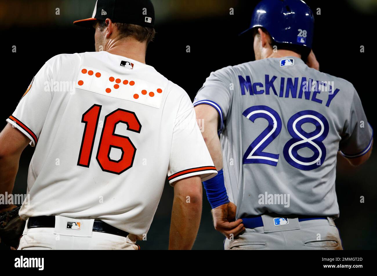 Baltimore Orioles first baseman Trey Mancini, left, wears a jersey
