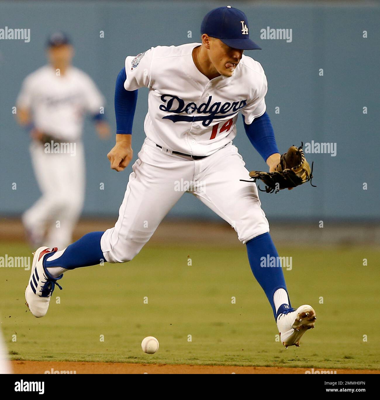 Los Angeles Dodgers second baseman Enrique Hernandez misses fielding a  ground ball on a Colorado Rockies' Nolan Arenado single during the first  inning of a baseball game in Los Angeles, Monday, Sept.