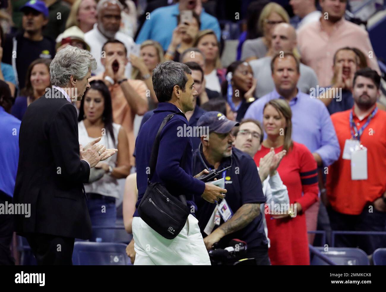 Chair umpire Carlos Ramos, right, is lead off the court by referee