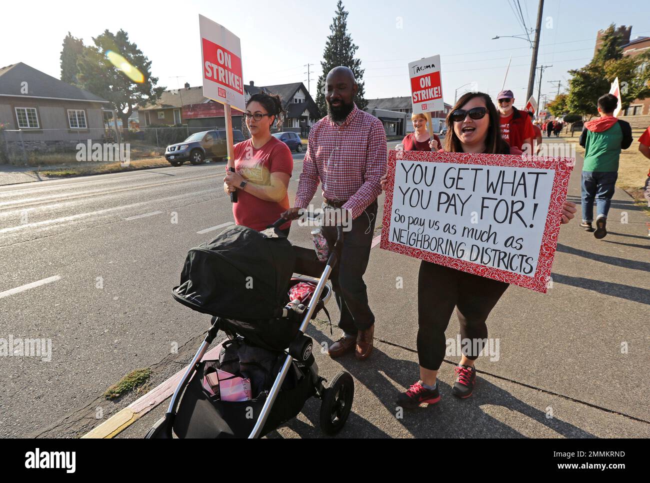 Striking Tacoma Teachers, including Megan Holyoke, left, Nate Bowling,  center, and counselor Michelle Ha, right, walk a picket line, Thursday,  Sept. 6, 2018, in front of Lincoln High School in Tacoma, Wash.