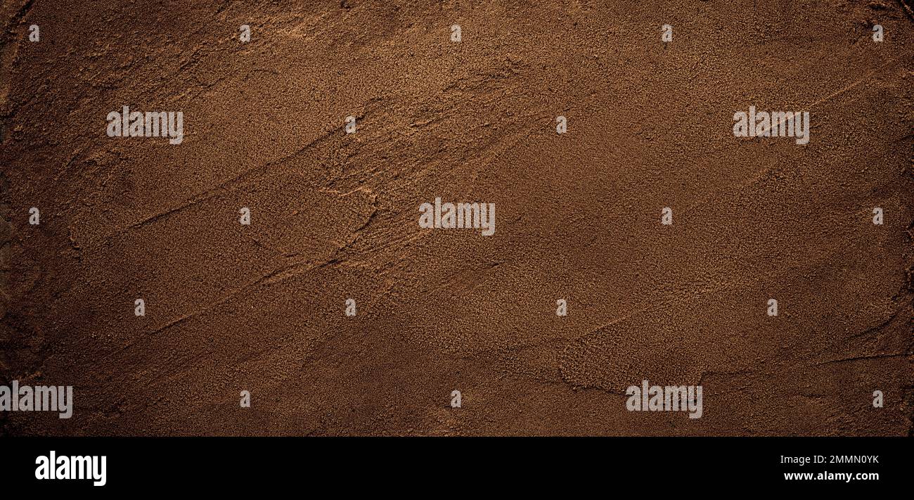 Dark chocolate brown sugar-like grainy texture background Stock Photo