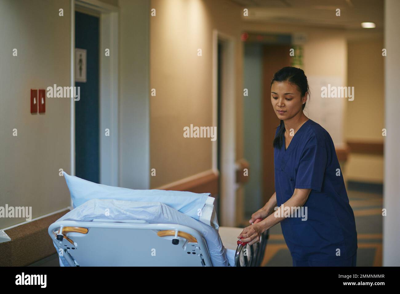 Shes on bed duty. a female nurse pushing a hospital bed down the