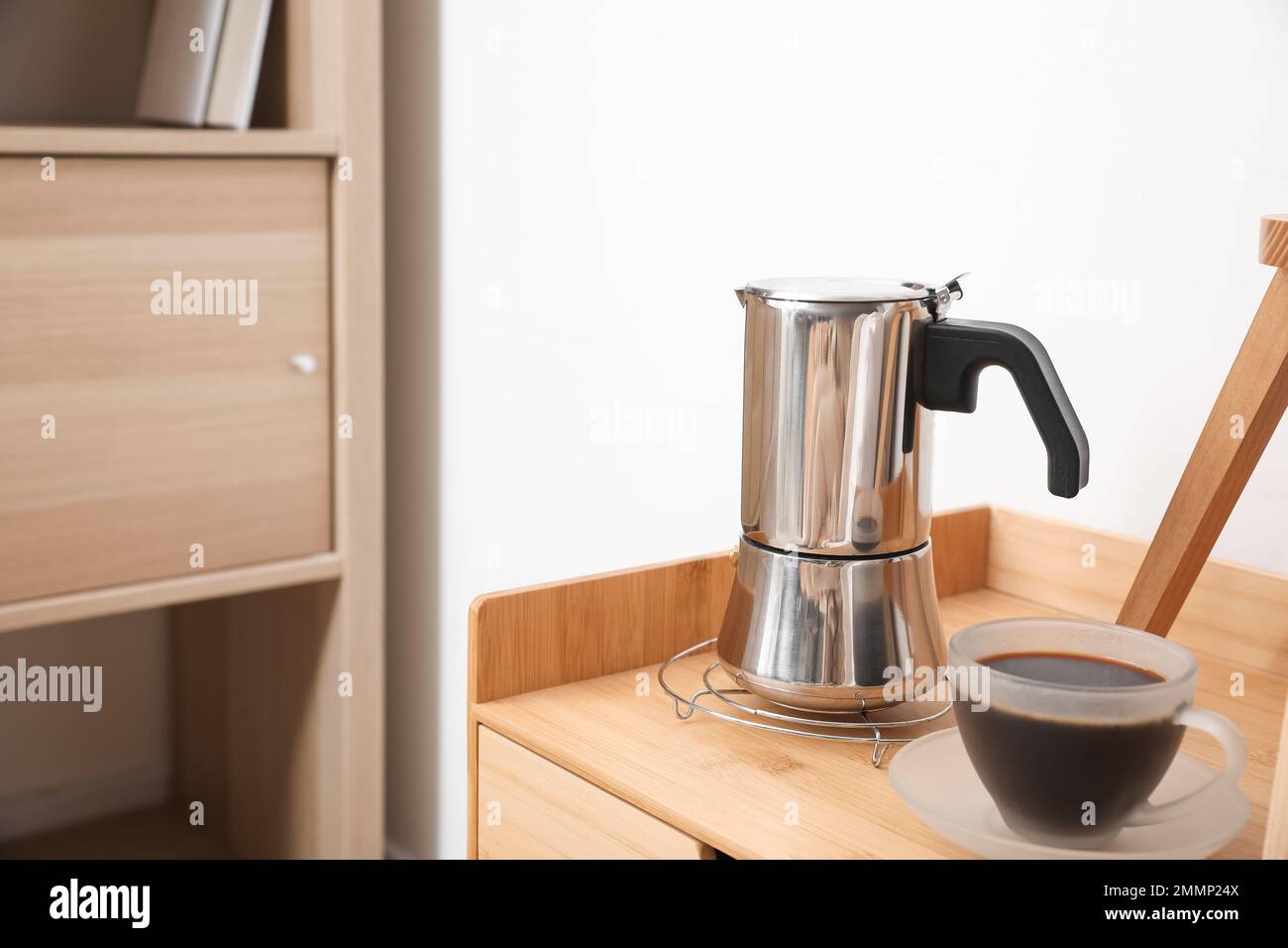 Geyser coffee maker and cup of espresso on nightstand table Stock Photo