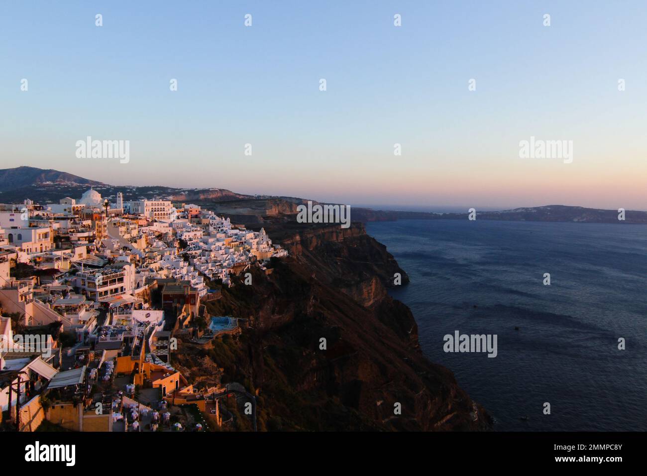 Sunset over looking the caldera and picturesque villages clinging to the hill side. Santorini, Greece Stock Photo