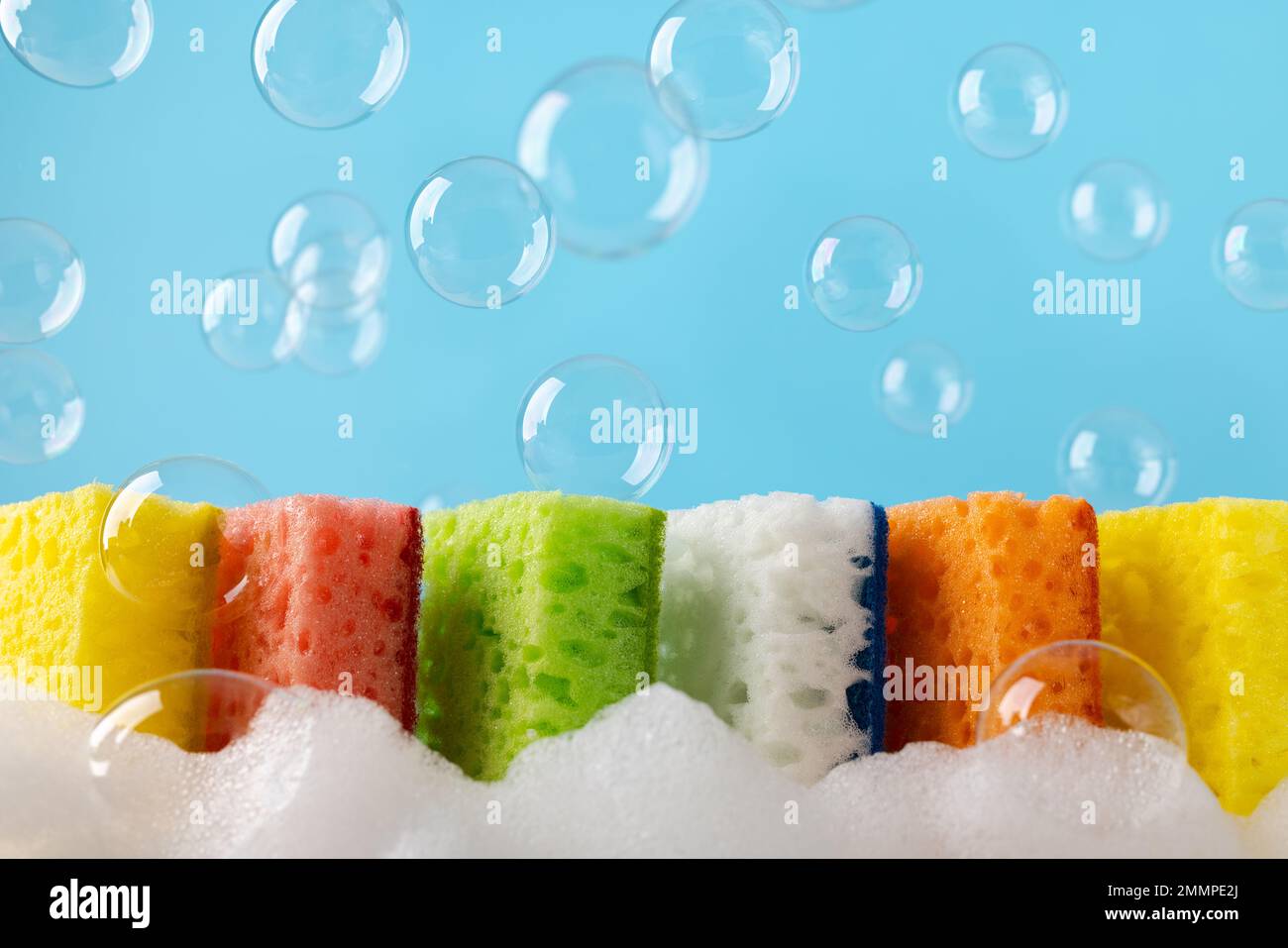 https://c8.alamy.com/comp/2MMPE2J/household-cleaning-scrub-colored-sponges-with-soap-foam-and-bubbles-kitchen-dishwashing-sponge-on-blue-background-cleaning-home-concept-space-for-t-2MMPE2J.jpg