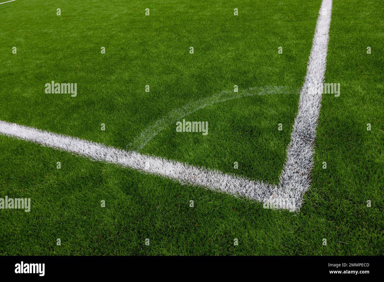 Photo of a green synthetic grass sports field with white line shot from