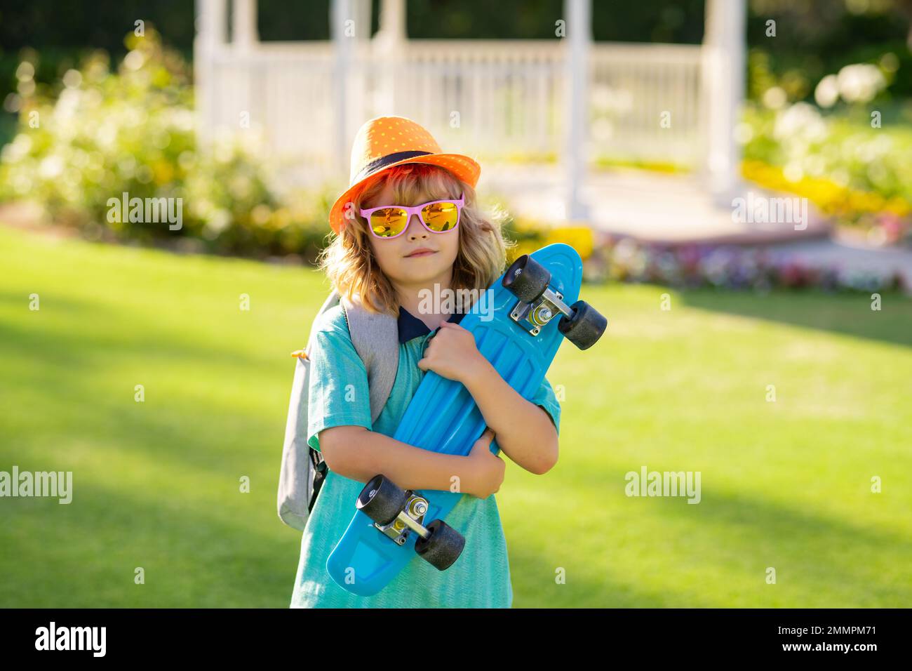 Summer kids fashion. Child boy holding longboard on pink background ...