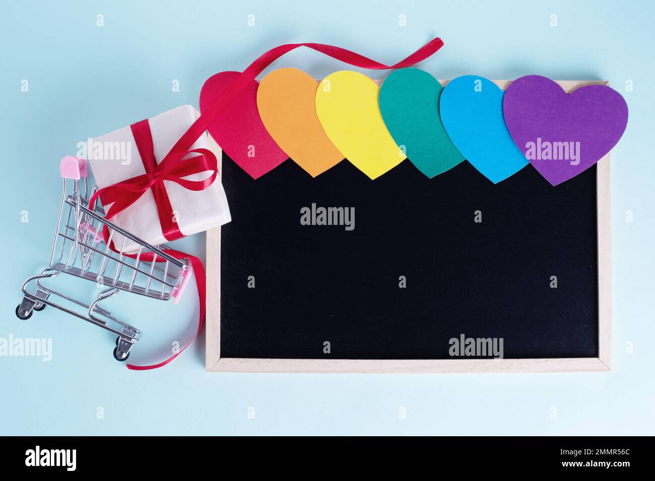 Gift box in shopping carts, multicolored rainbow colored paper hearts