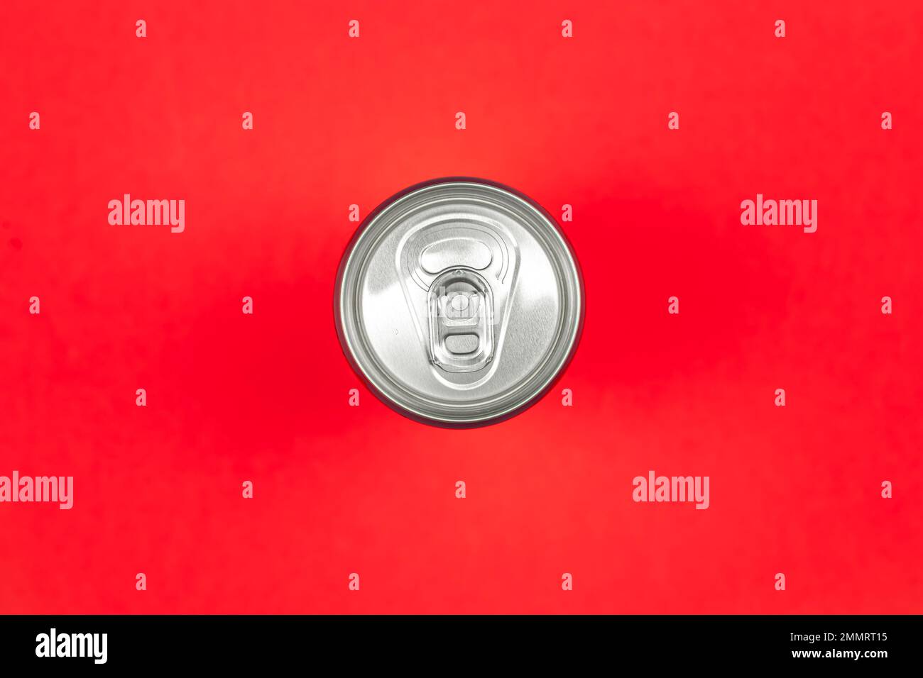 Aluminum drink or beverage can with pull ring on a red background, flat lay. Stock Photo