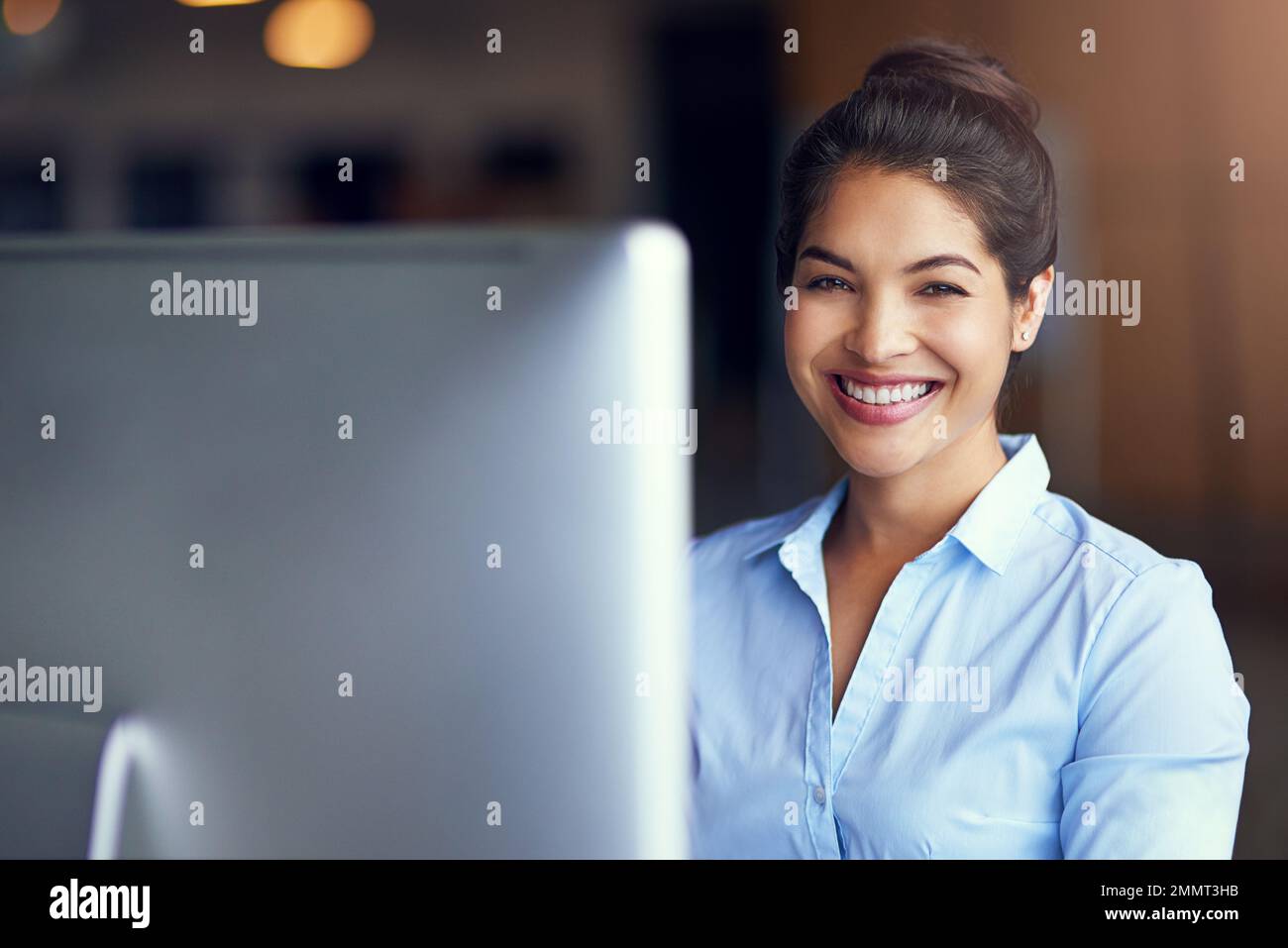 Tackling her work with a can-do attitude. Portrait of a young businesswoman sitting at her office computer. Stock Photo