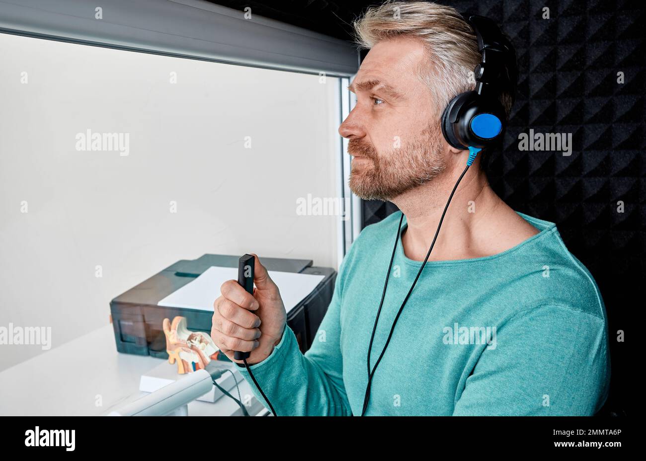 Hearing test for adult man. Handsome mature male during hearing exam ...