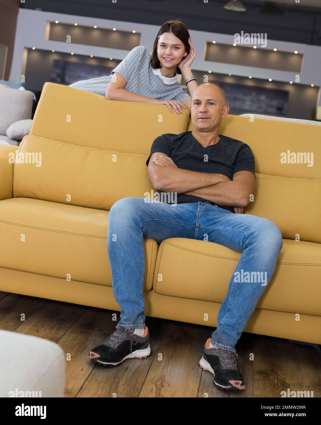 Couple sitting on yellow sofa Stock Photo