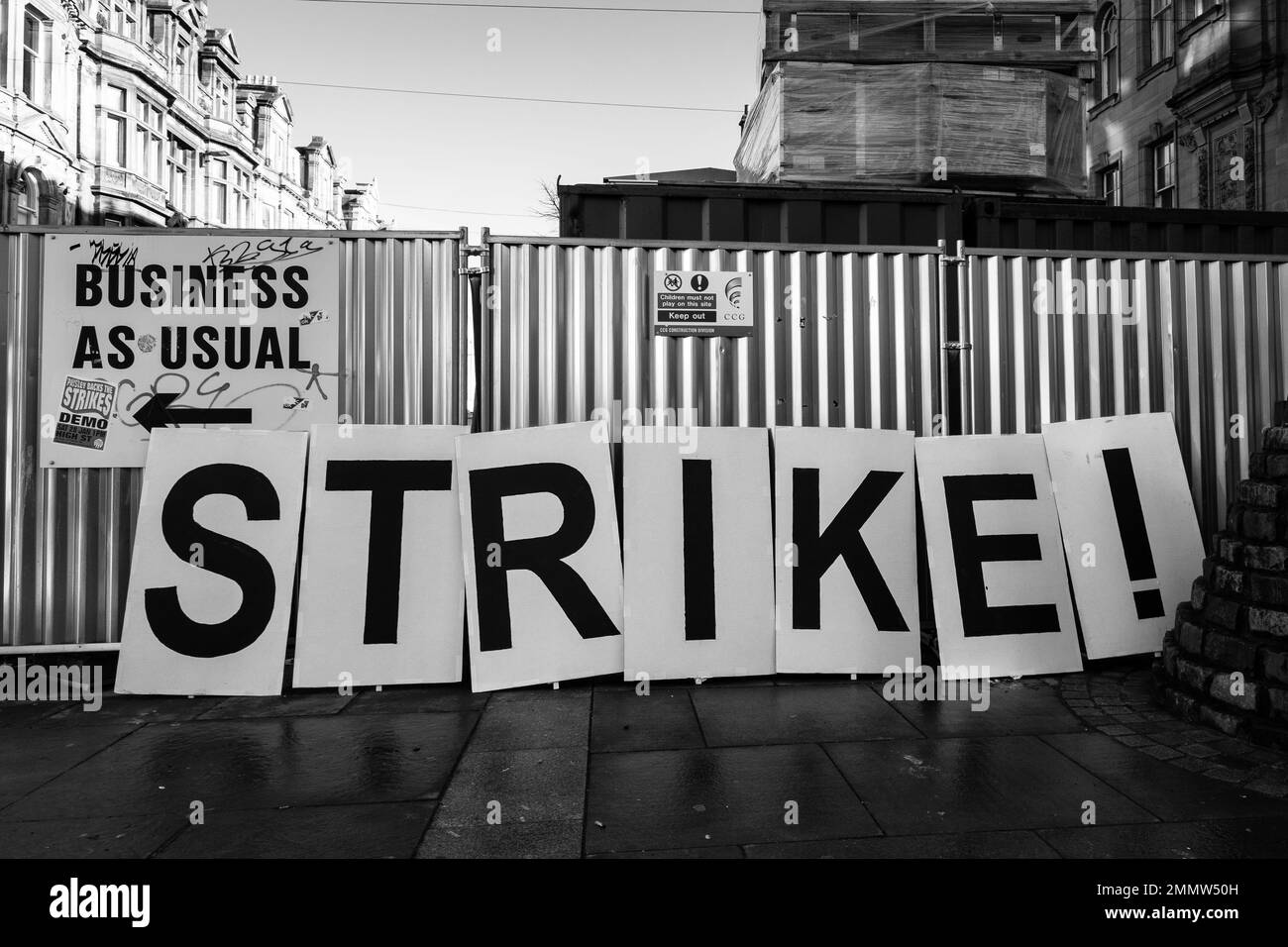 A Strike placard next to a Business As Usual sign Stock Photo