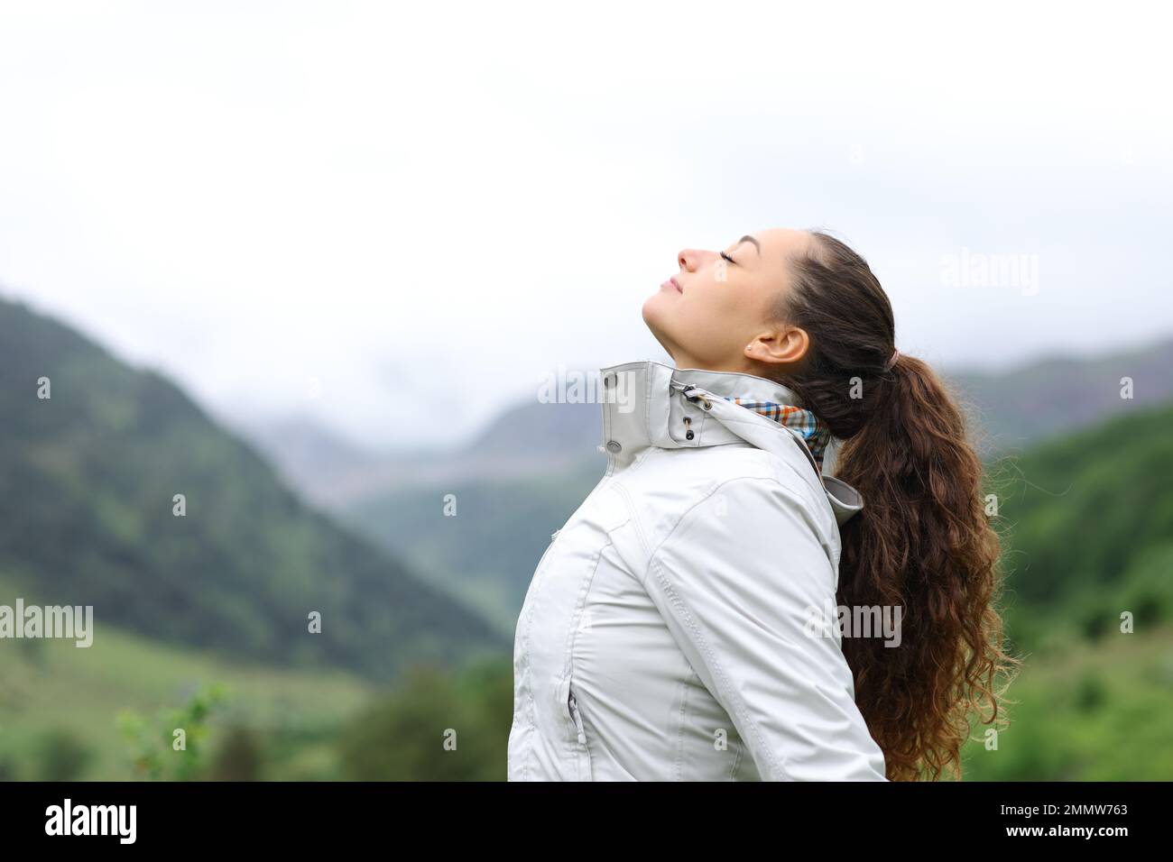 Profile of a hiker breathing fresh air in nature Stock Photo