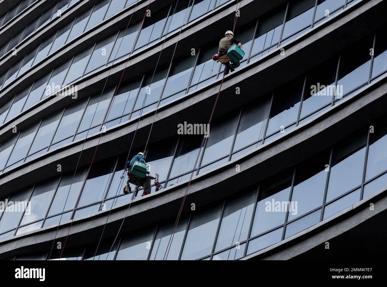 two workers are washing windows at a height. Professional cleaning