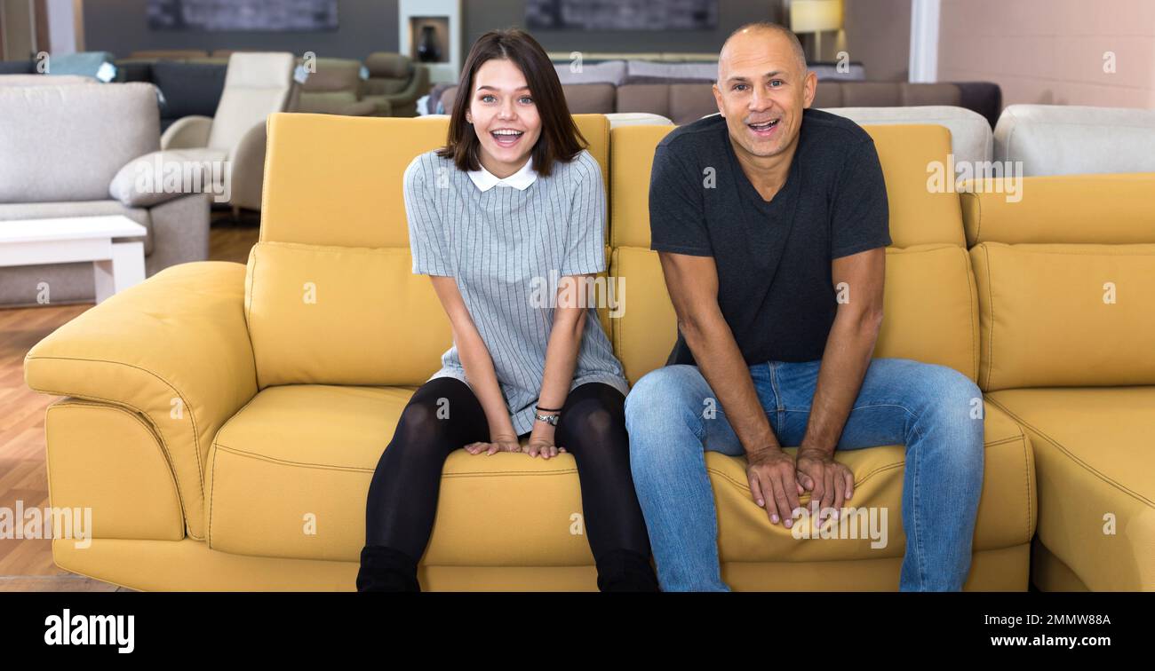 Couple sitting on yellow sofa Stock Photo