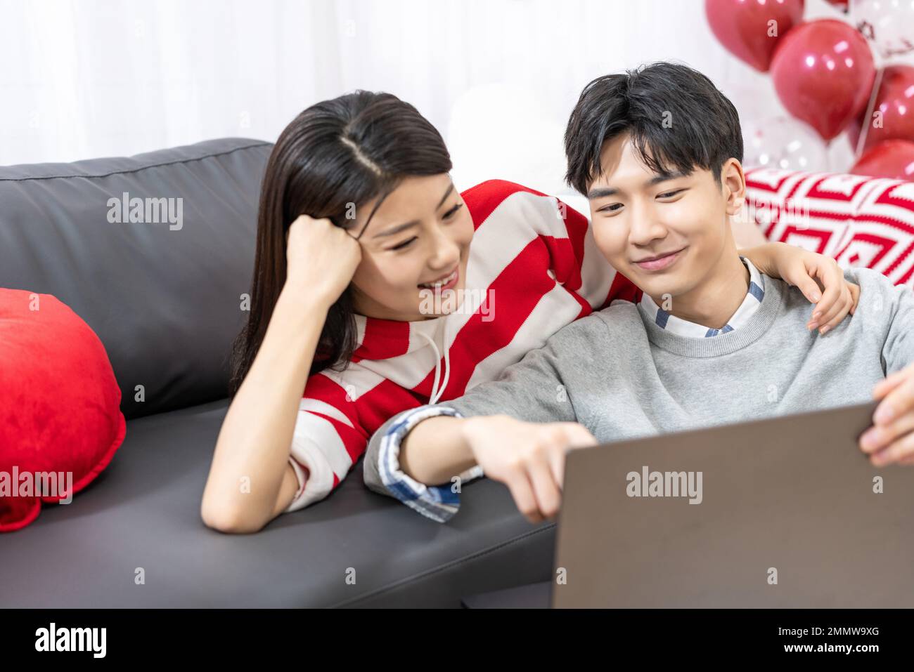 Young couples using laptop at home Stock Photo
