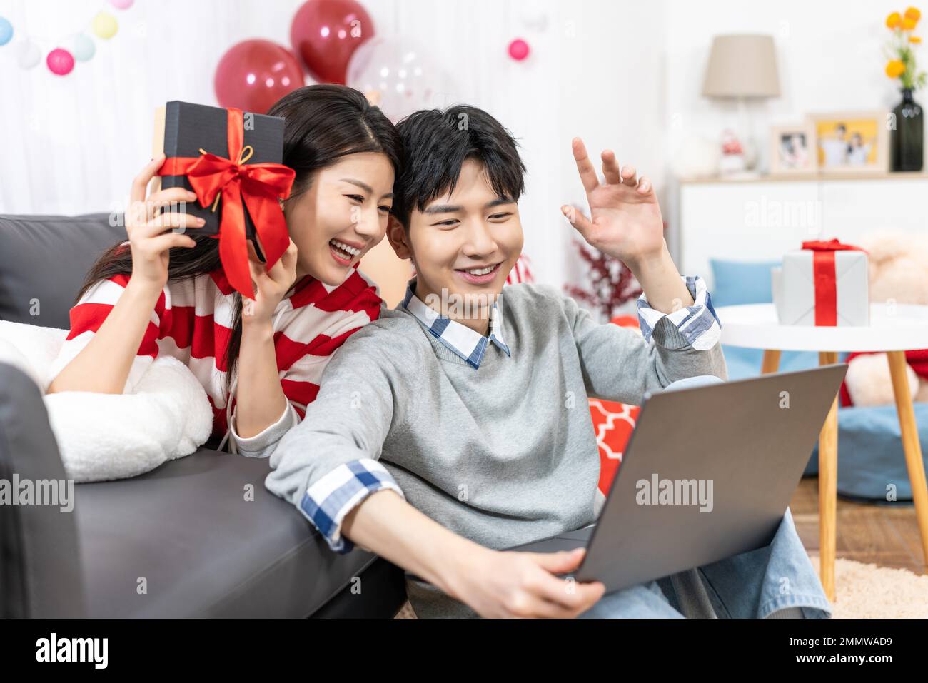 Young couples using laptop at home Stock Photo