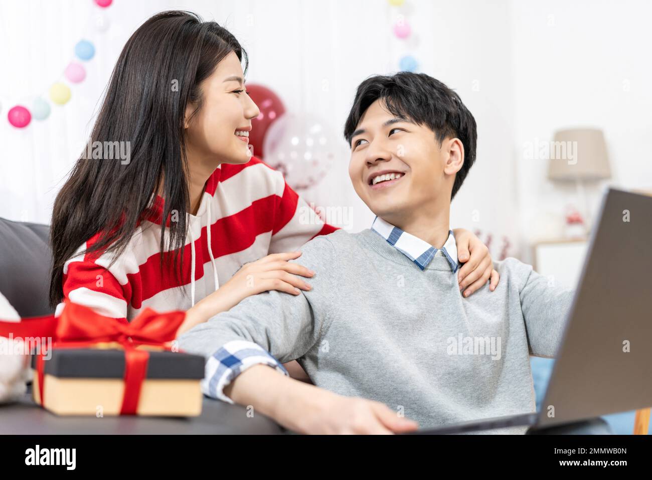 Young couples using laptop at home Stock Photo