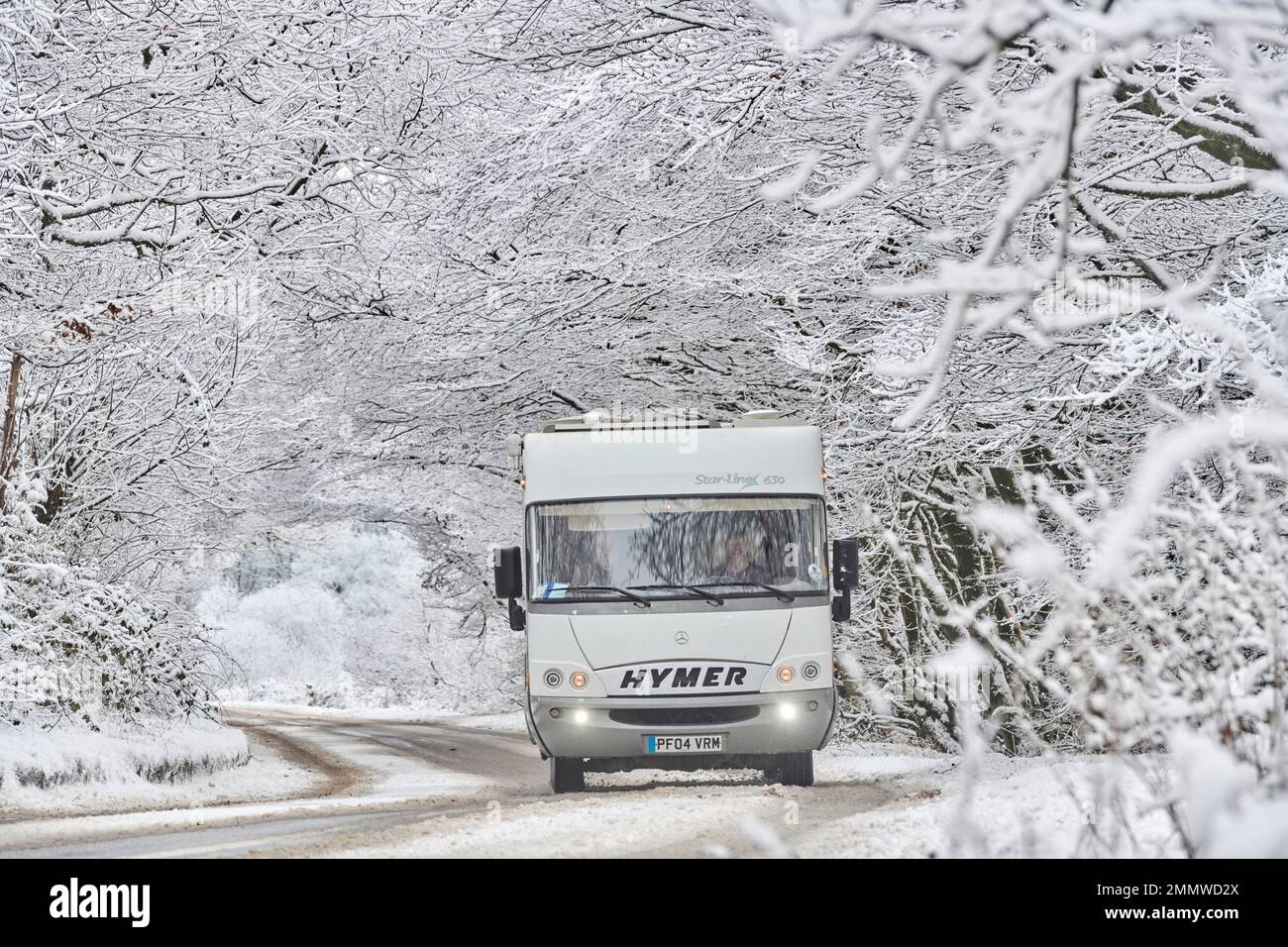 A motorhome driving through snow conditions in winter on Exmoor, UK
