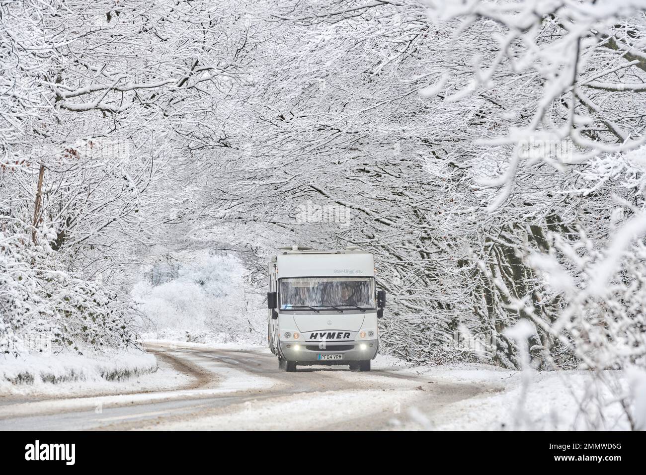 A motorhome driving through snow conditions in winter on Exmoor, UK