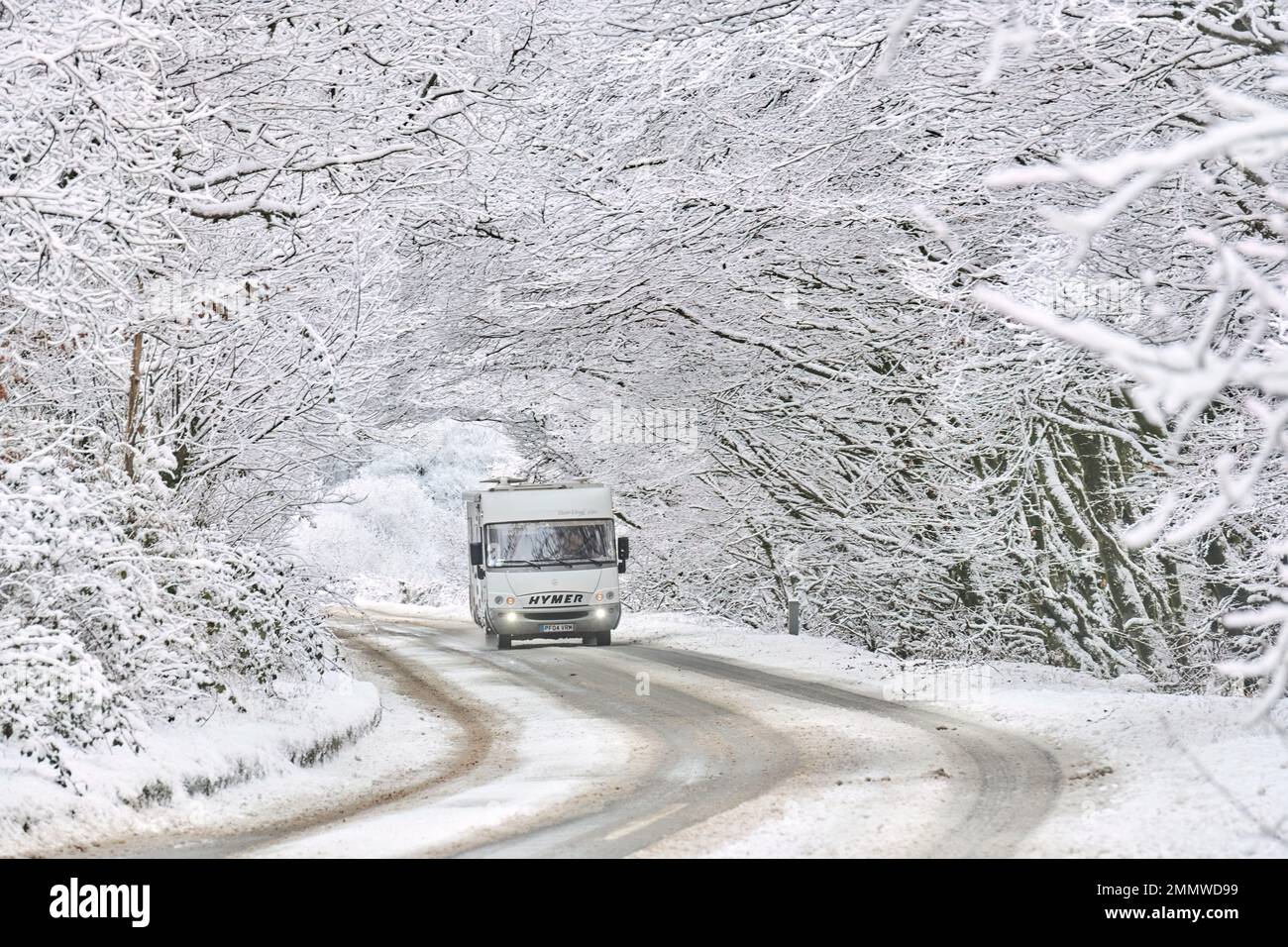 A motorhome driving through snow conditions in winter on Exmoor, UK