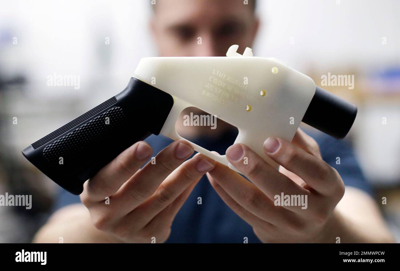 Cody Wilson, with Defense Distributed, holds a 3D-printed gun called ...