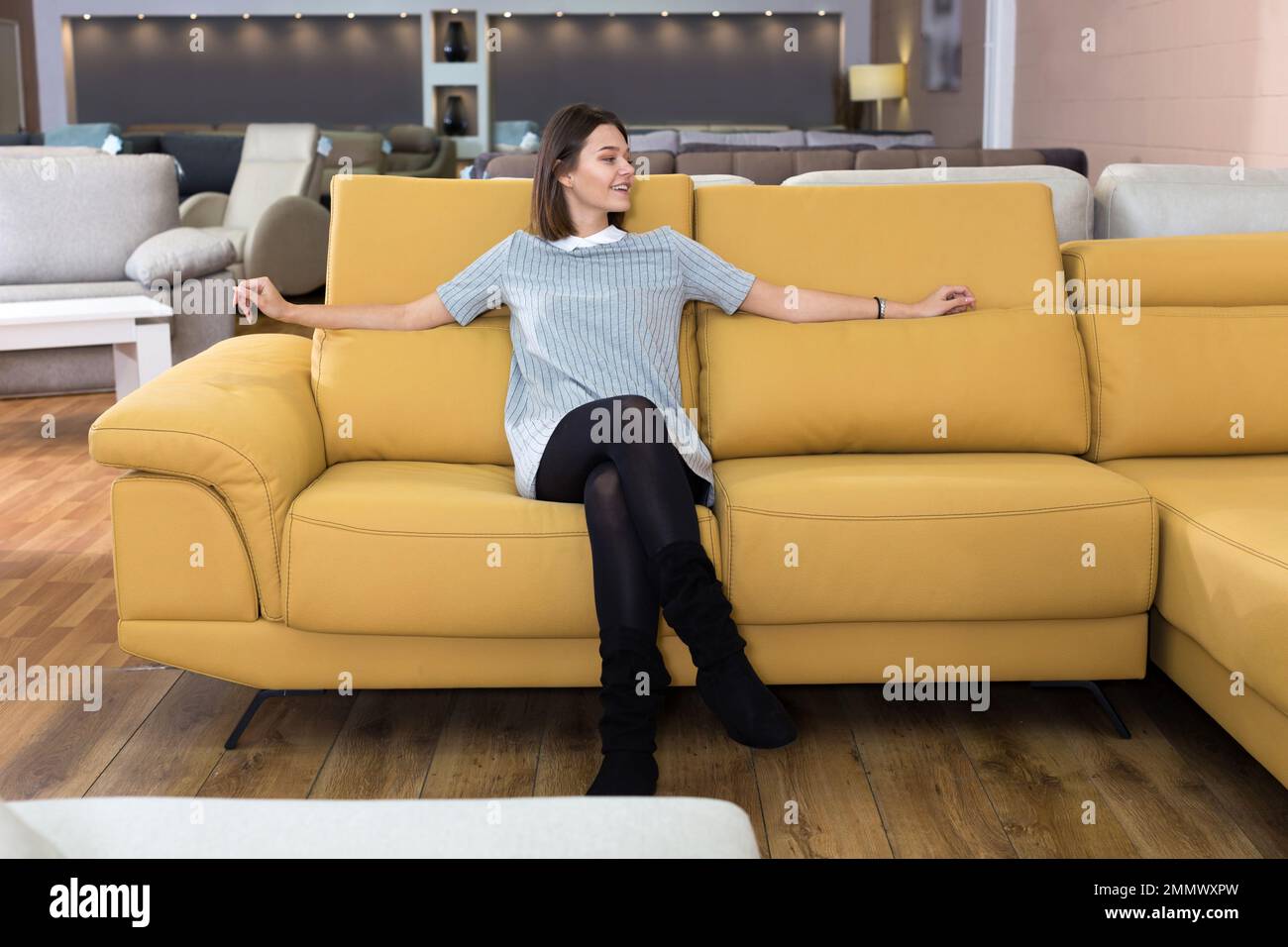 Woman testing sofa in furniture store Stock Photo Alamy
