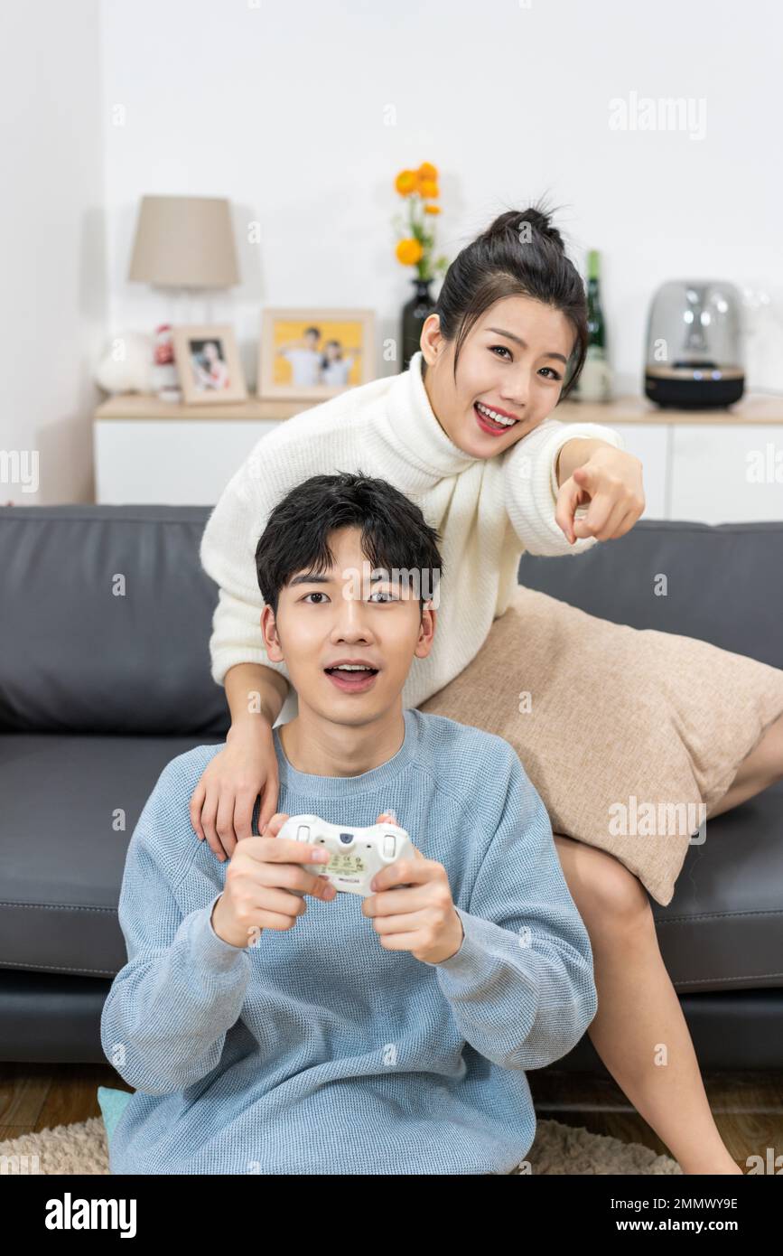 Young Cute Competitive Boyfriend Girlfriend Playing Video Games In Couch  Stock Photo, Picture and Royalty Free Image. Image 34313215.