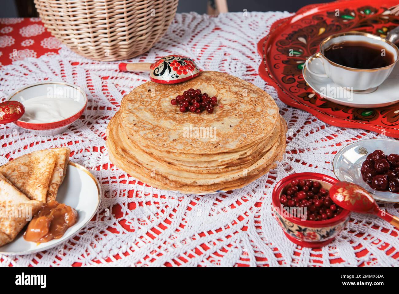 Pancakes with berries and sour cream on the table. Shrovetide Maslenitsa festival concept. Stock Photo
