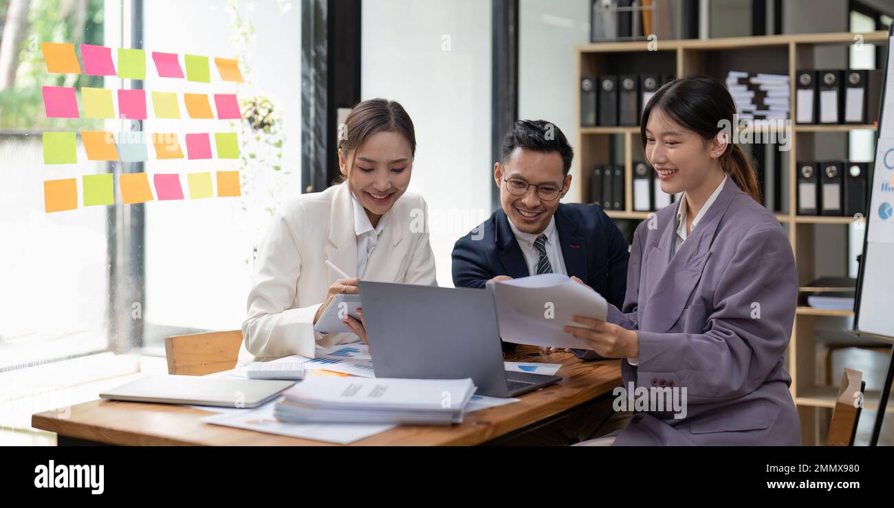 Group of young business people working and communicating while sitting at the office desk together with colleagues. Project and Business concept Stock Photo