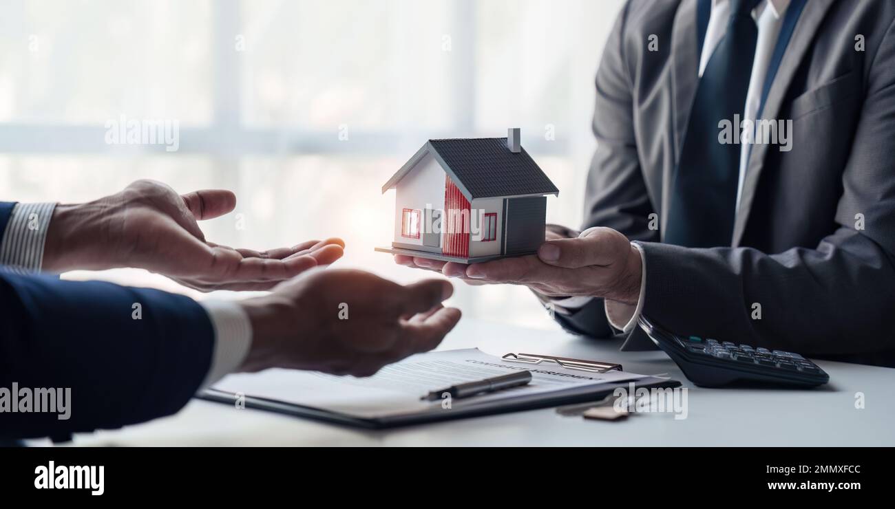 Close up of Real estate agent to buy houses and land are delivering keys and houses. Discussion