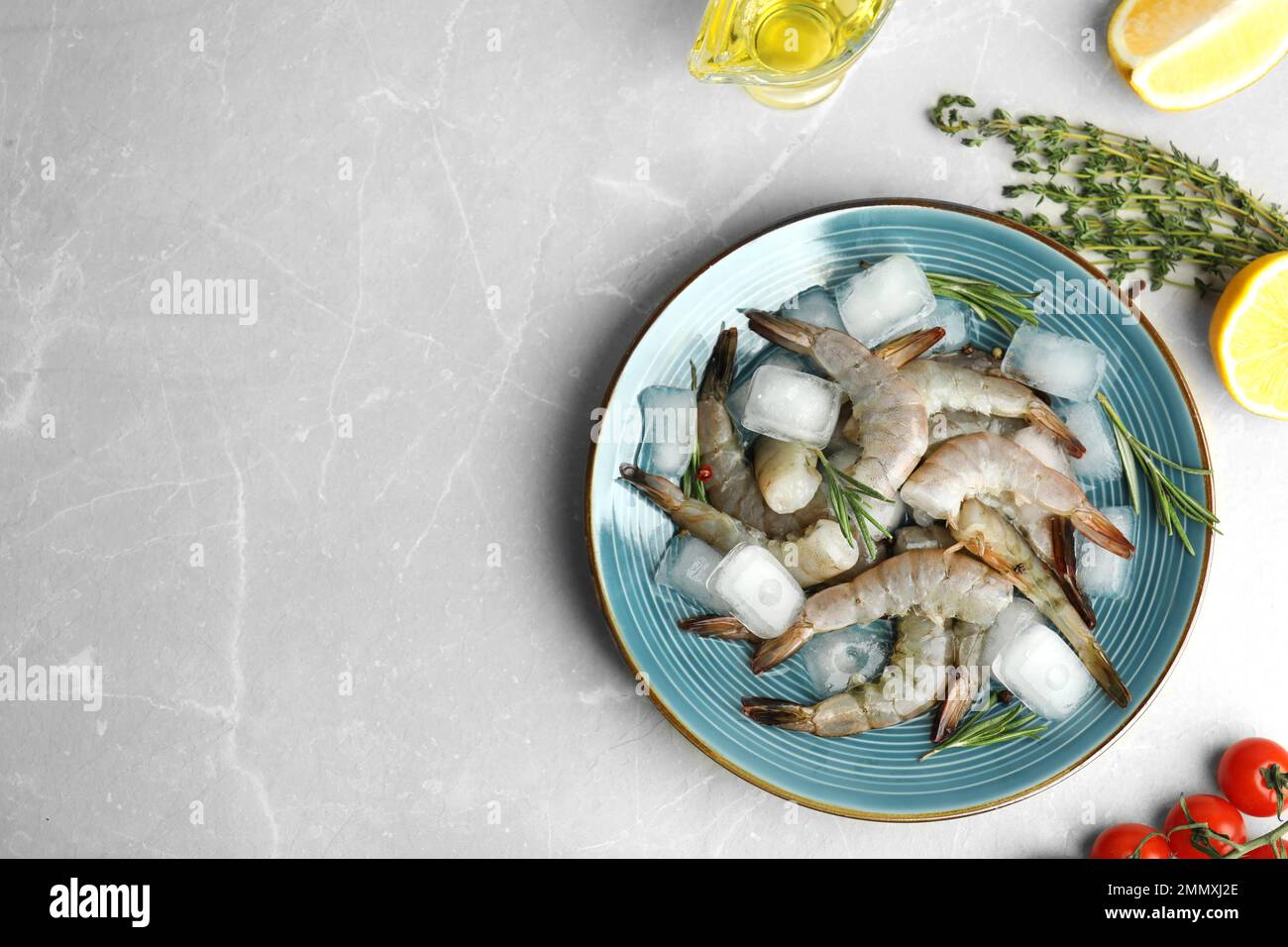 Flat lay composition with fresh raw shrimps on light grey marble table ...