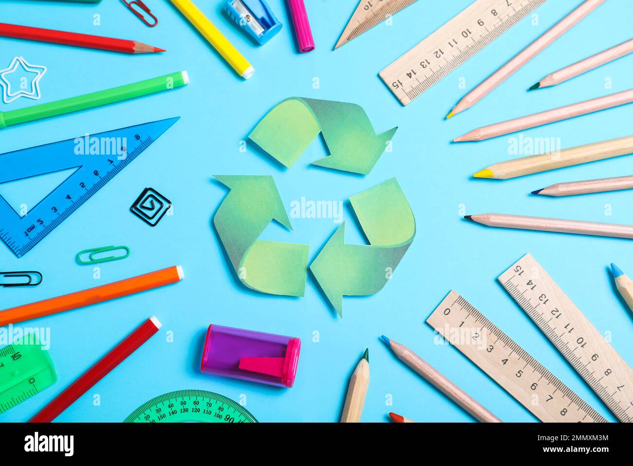 Recycling symbol, plastic and wooden stationery on light blue