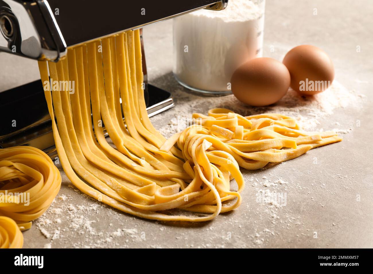 Table For Pasta Machine Pasta maker machine with dough and products on grey table Stock Photo ...