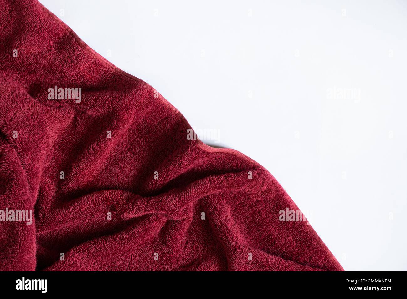 red towel folded lies on a white background, bath red towel on an isolated background Stock Photo