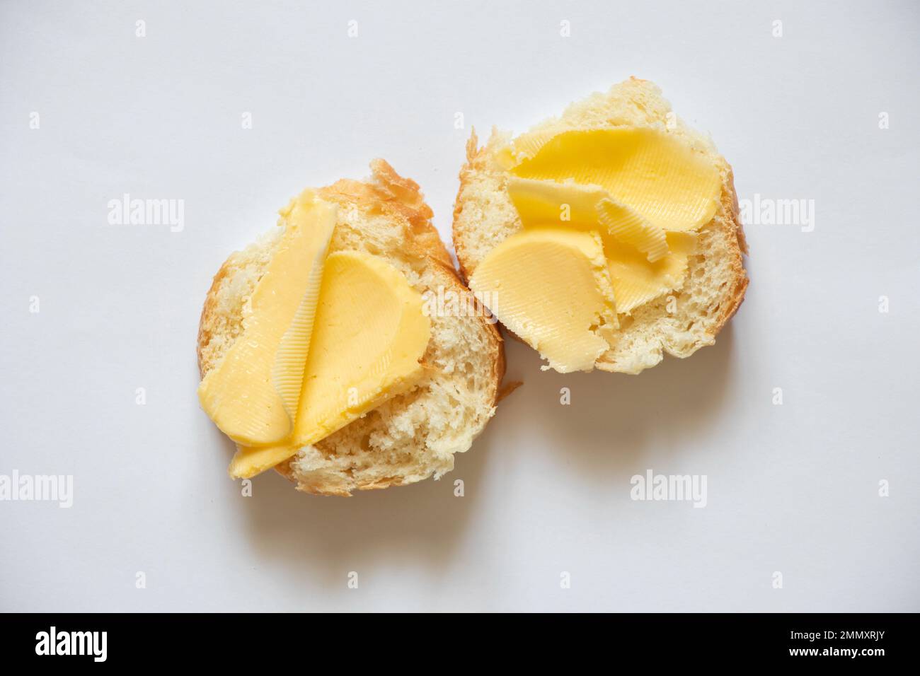 white bread with butter on a white background, a slice of bread and
