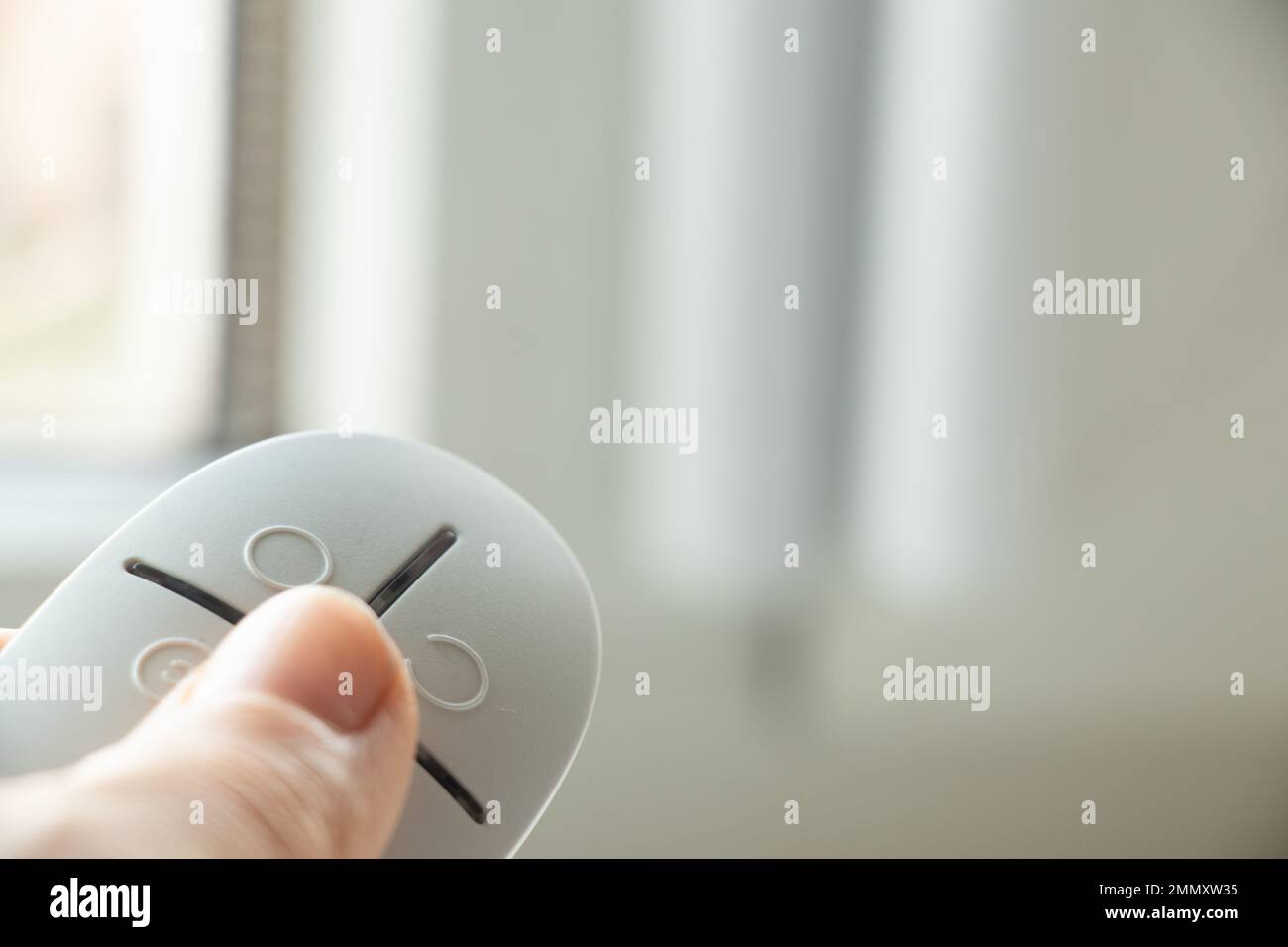 home security system on the windows, an opening sensor and a remote control in the hands of opening and closing, an alarm remote control Stock Photo