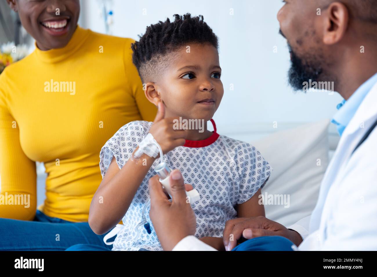 African american male doctor explaining inhaler to boy patient and ...