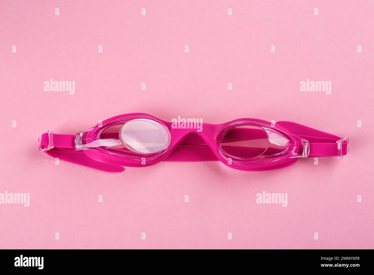 Swimming goggles on pink background, top view Stock Photo