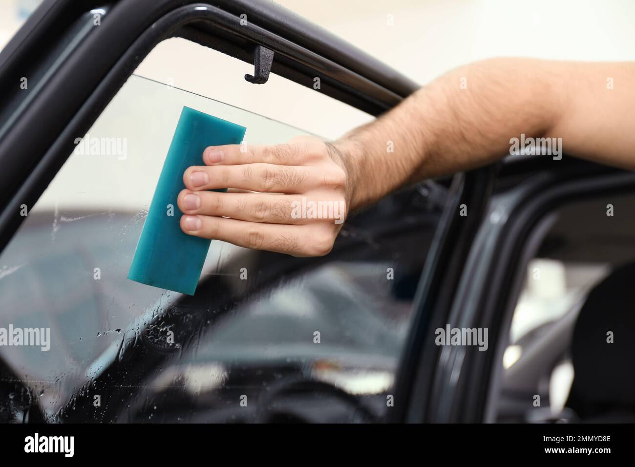 Male hand with spray, car window tint installation process, installing  procedure, tinting film Stock Photo - Alamy