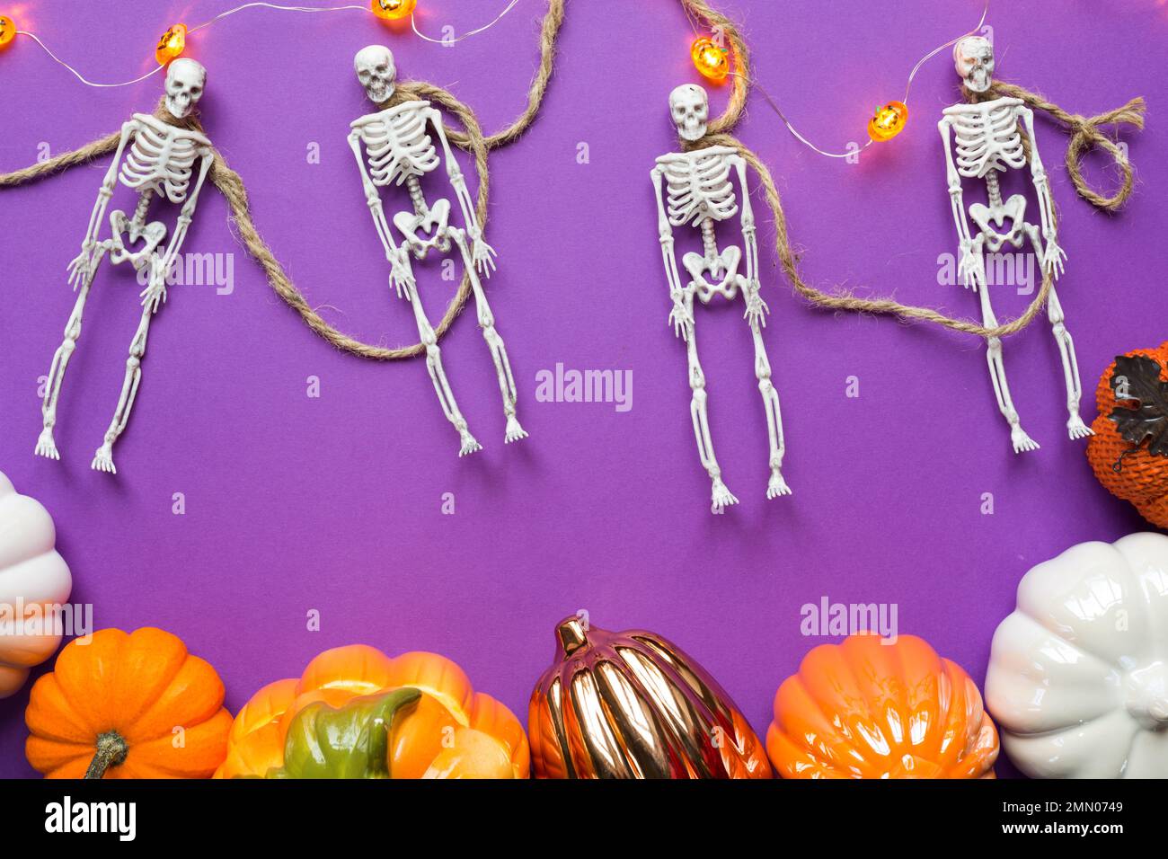 Halloween layout of garland of skeleton on a rope, glowing Jack o ...