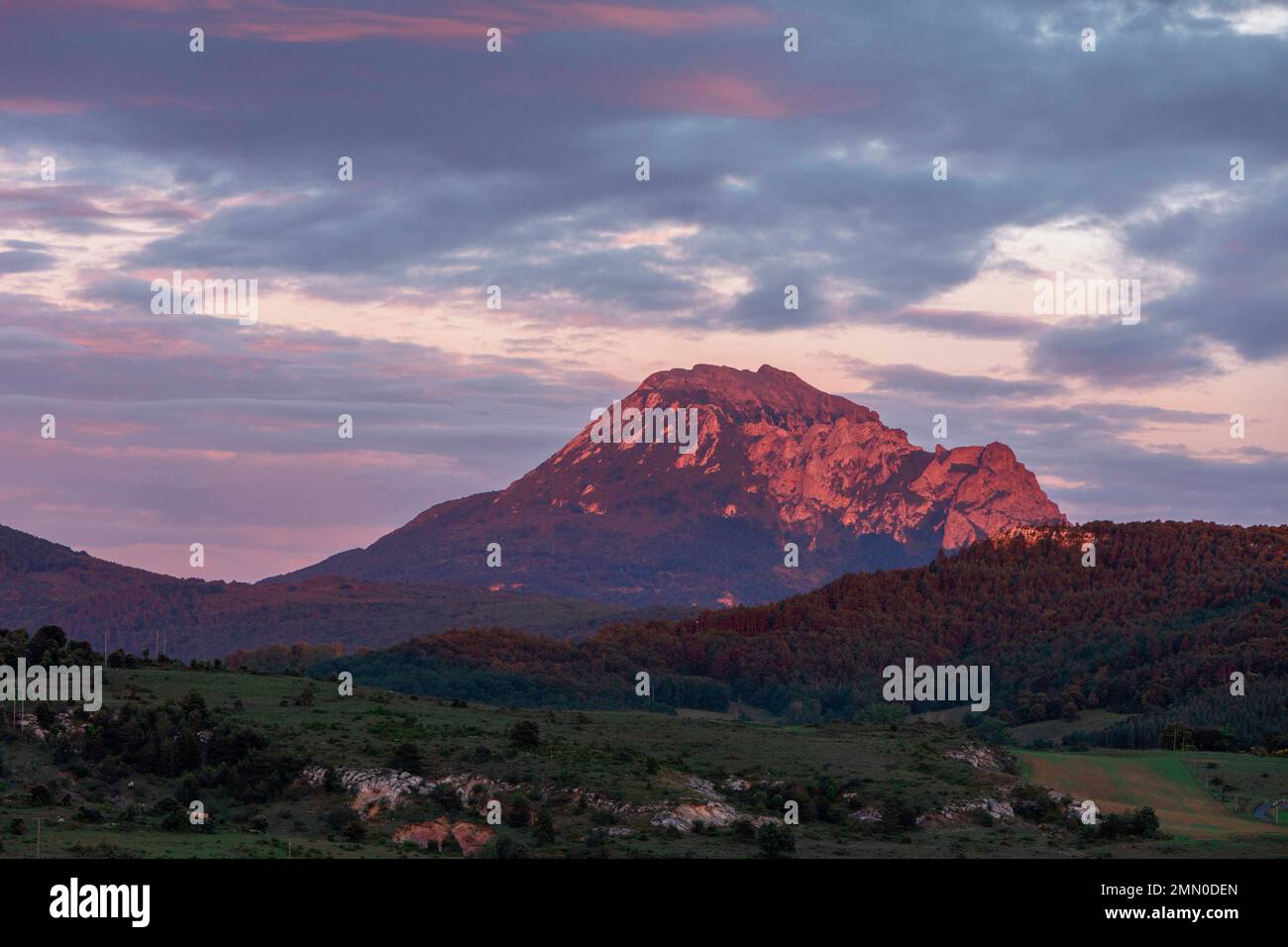 France, Aude, Rennes le Chateau, Mont Bugarach, mountain lit by the last rays of the sun under a cloudy sky Stock Photo