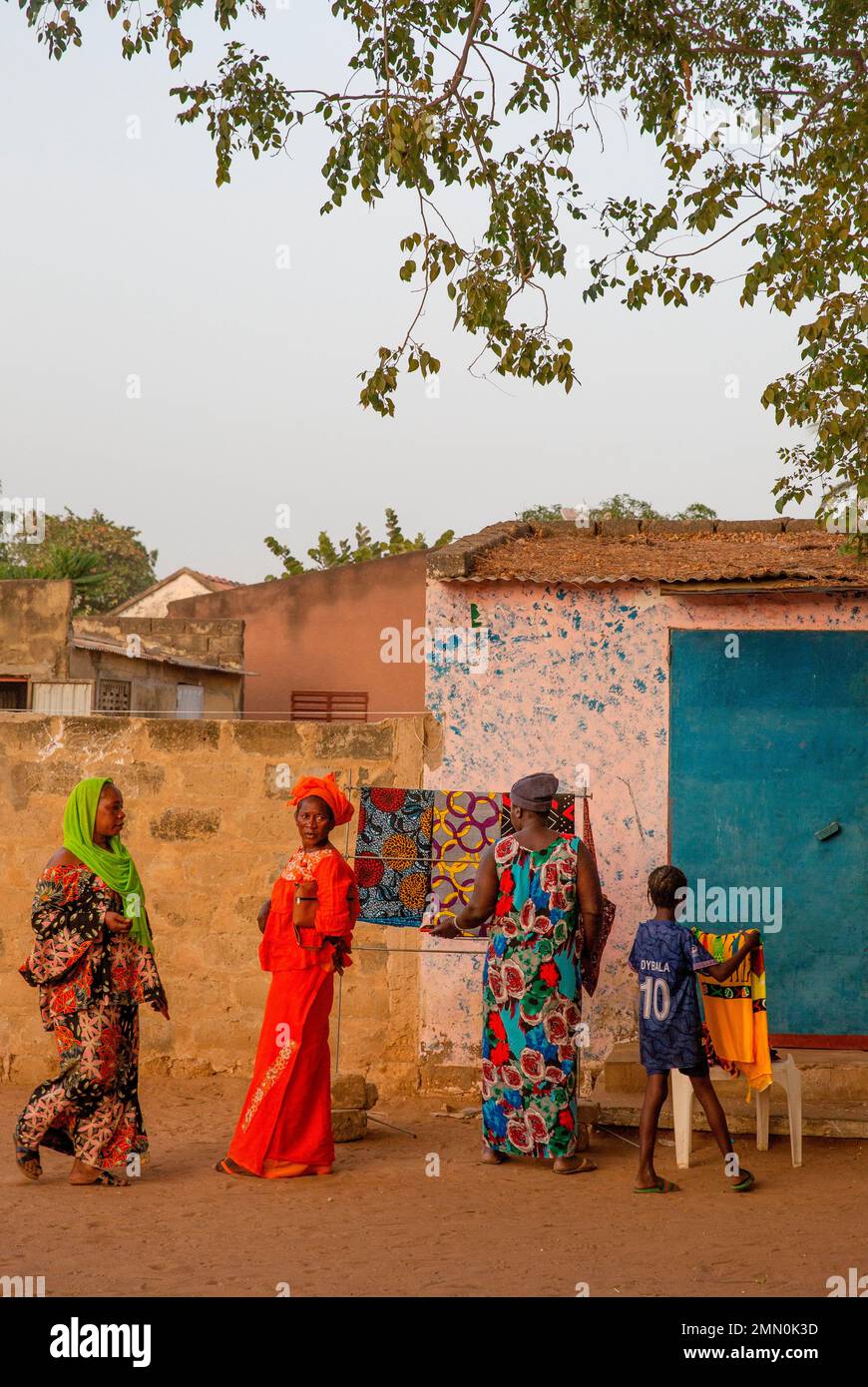 Senegal, Saloum delta listed as World Heritage by UNESCO, women in colorful boubous in front of a wax fabric shop on the main square of the village of the island of Mar Lodj Stock Photo
