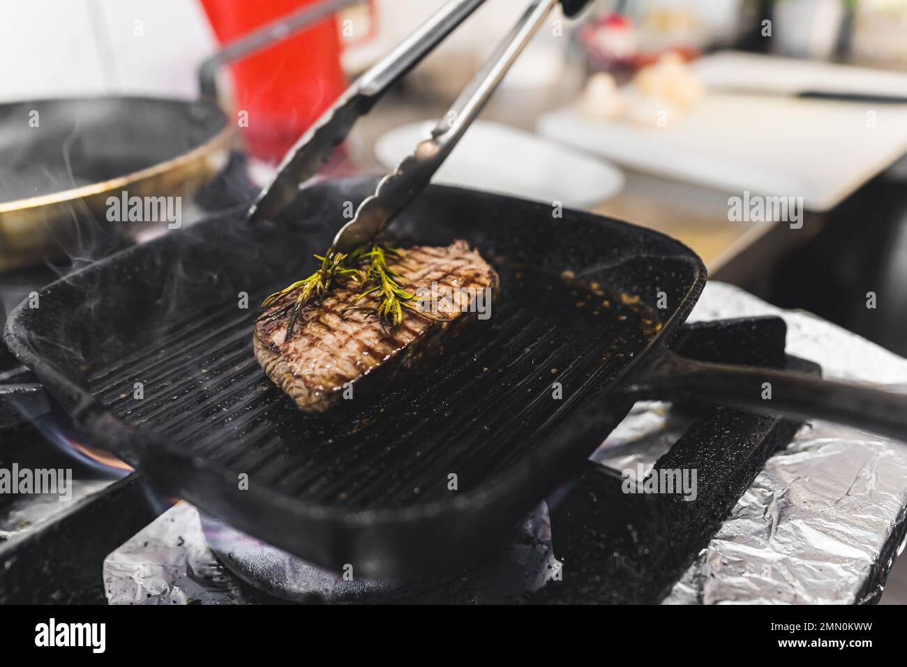 Beef striploin steak prepared on a grill frying pan with herbs