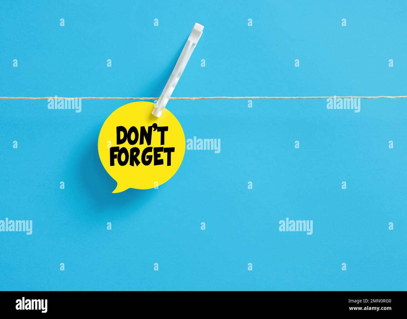 Don't forget message reminder on a speech bubble hanging on clothesline ...